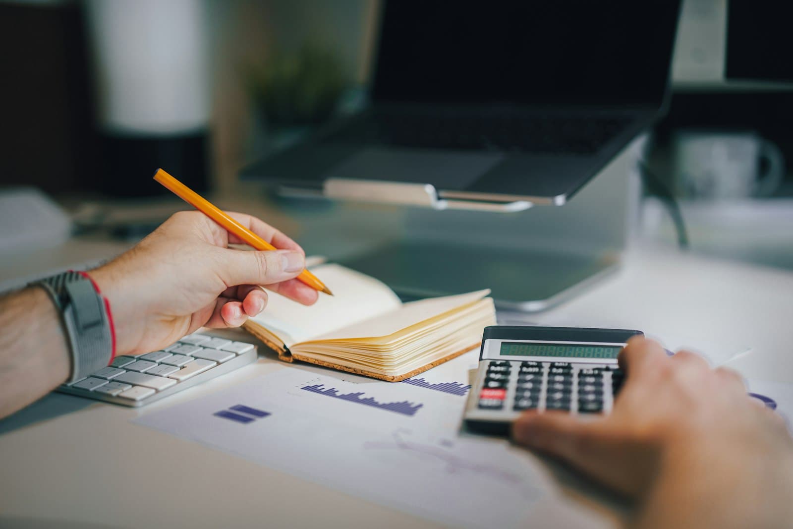 Accounting desk with a calculator, notebook and financial papers